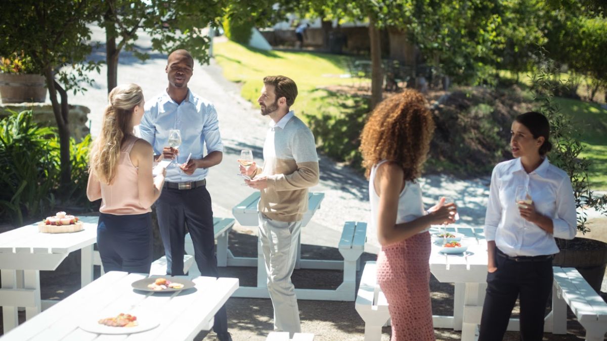 A vibrant scene from a corporate event retreat where colleagues are connecting and building relationships over drinks and snacks.