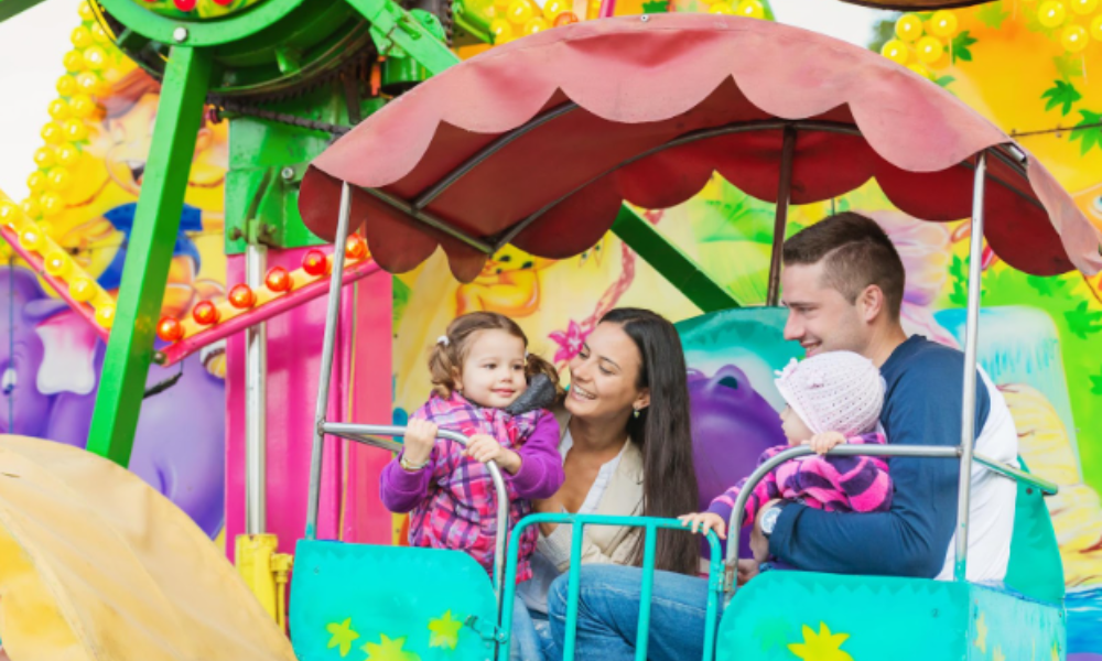 A family laughing and enjoying a carnival ride, capturing the essence of fun and togetherness in group and family travel planning.