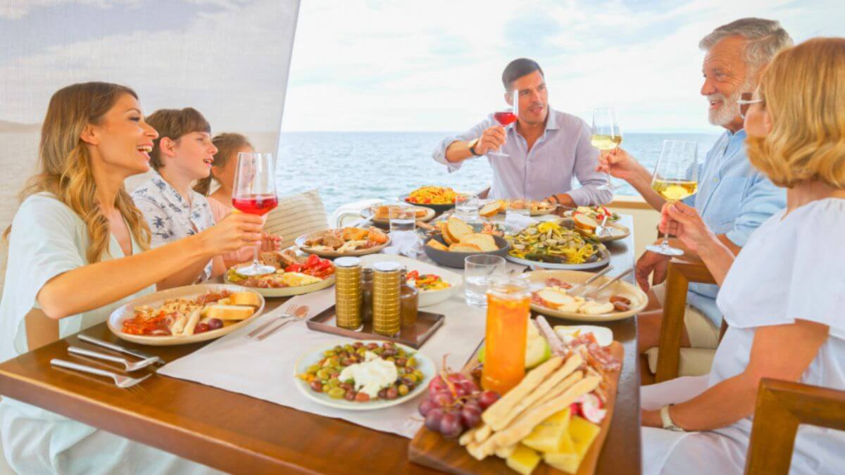 A family happily sharing a meal on a boat, enjoying their time while talking about their group and family travel planning experience.