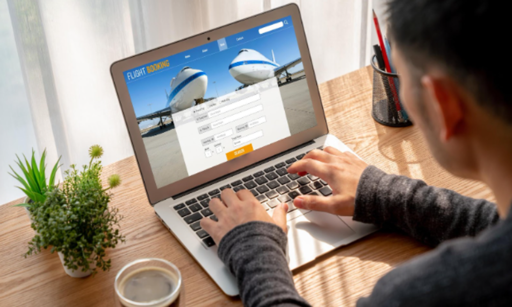 Corporate Event Retreats Go Global: International Planning Made Simple 2 A man booking a flight on a laptop, focused on planning for an international corporate event retreat.