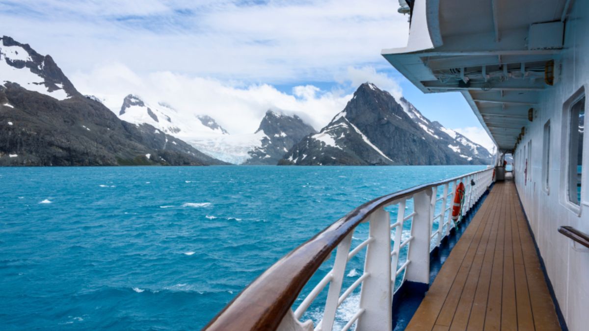 A cruise ship deck overlooking majestic mountains during an Antarctica Expedition.