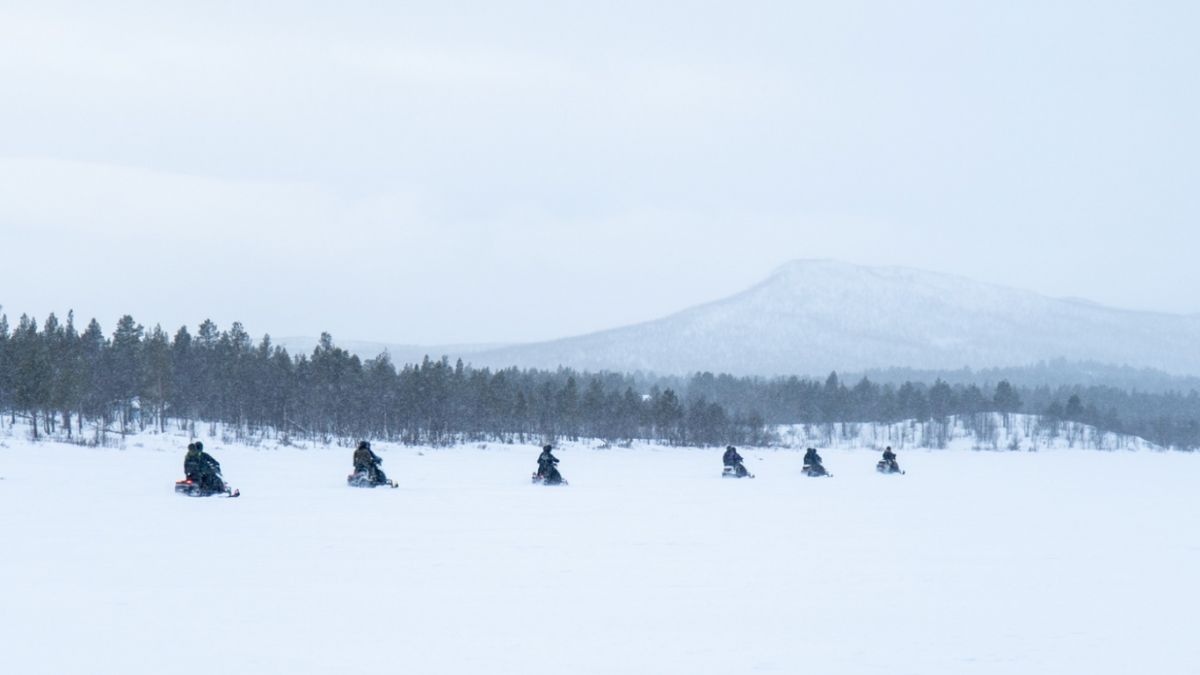 Expedition Travel: 5 Unforgettable Journeys Across the Globe 3 Several individuals on snowmobiles navigating a snowy terrain, showcasing an expedition travel experience.