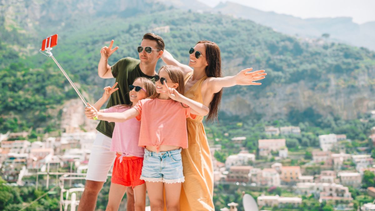 A family smiles as they take a selfie with a camera, celebrating their shared experience in group and family travel planning.
