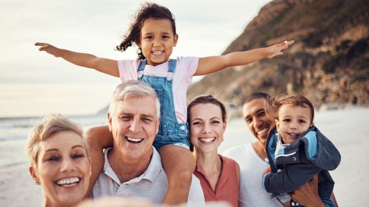 A family happily taking a beach selfie together during group travel.