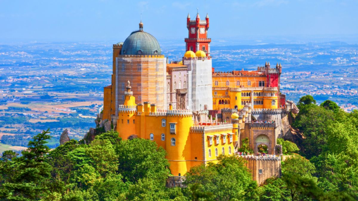 A majestic castle sits atop a hill in Sintra, Portugal, highlighting its grandeur as a UNESCO World Heritage site for luxury travel enthusiasts.