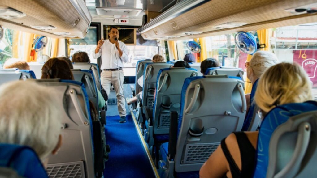 Galápagos Islands Cruise vs Land-Based Tours: Which Is Right for You? 2 A man speaks to passengers on a bus as part of a Galápagos Islands land-based tour.