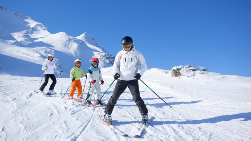A family skiing together, showcasing family travel planning in a winter landscape.