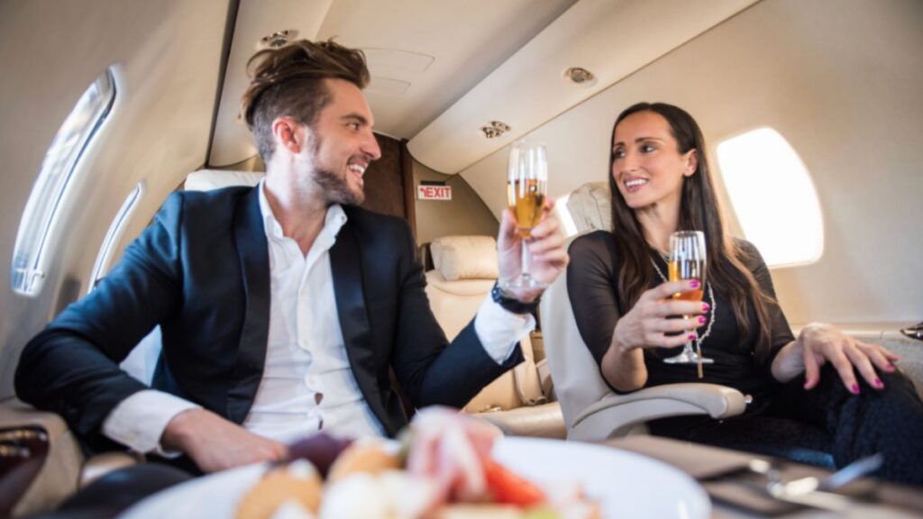 Inside a private jet, a man and woman celebrate with a toast, highlighting the essence of luxury travel planning.