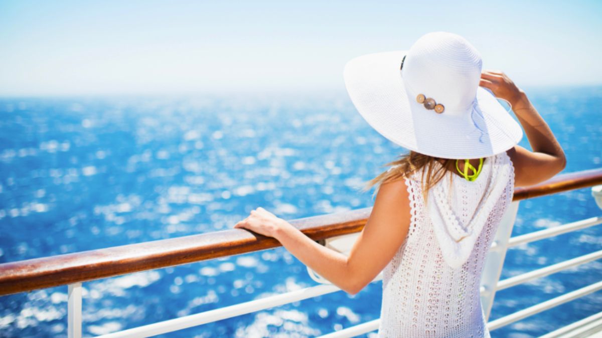 A woman in a white hat enjoys her river cruise experience.