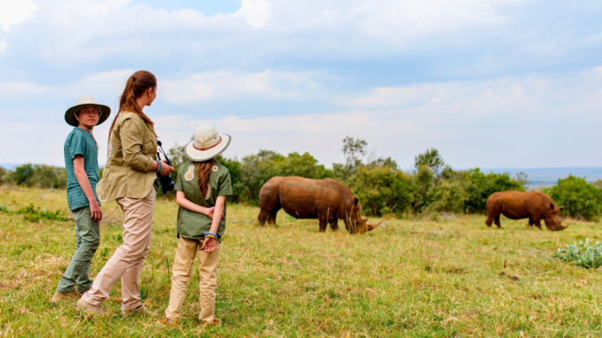 A family observing rhinos from a safe distance during their safari in Africa.