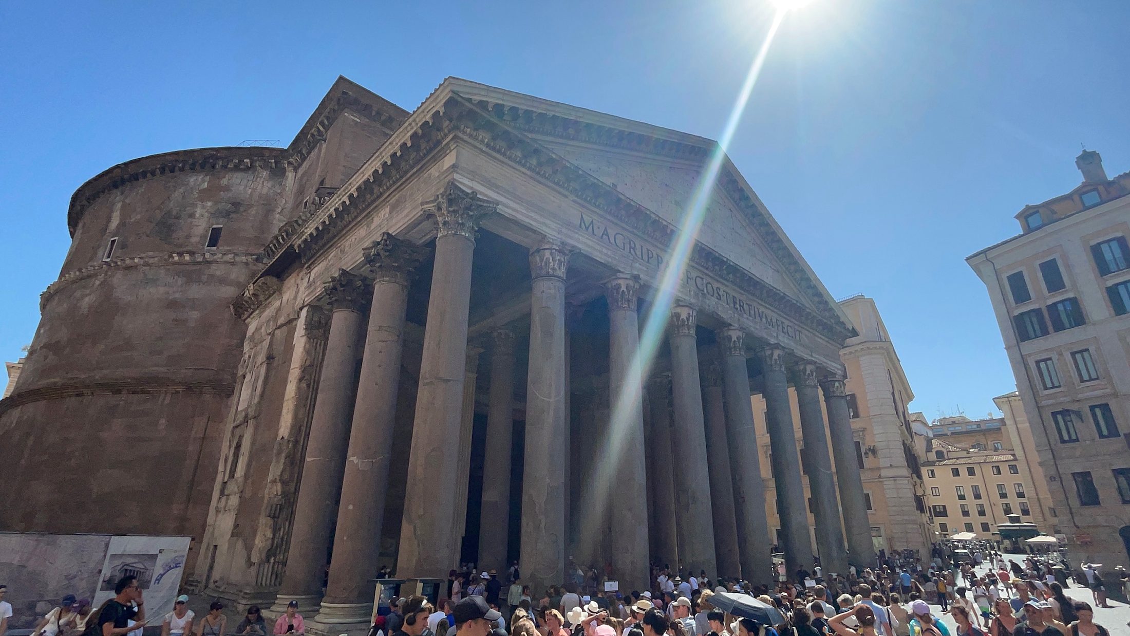 The Pantheon in Rome under bright summer sun with visitors in the piazza