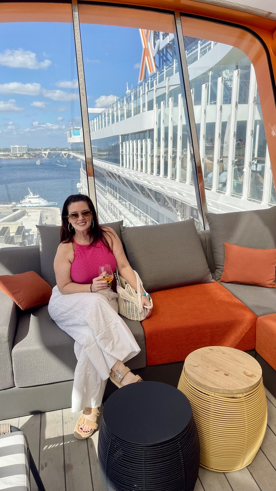 Guest relaxing in a ship lounge with a cruise ship beyond the window