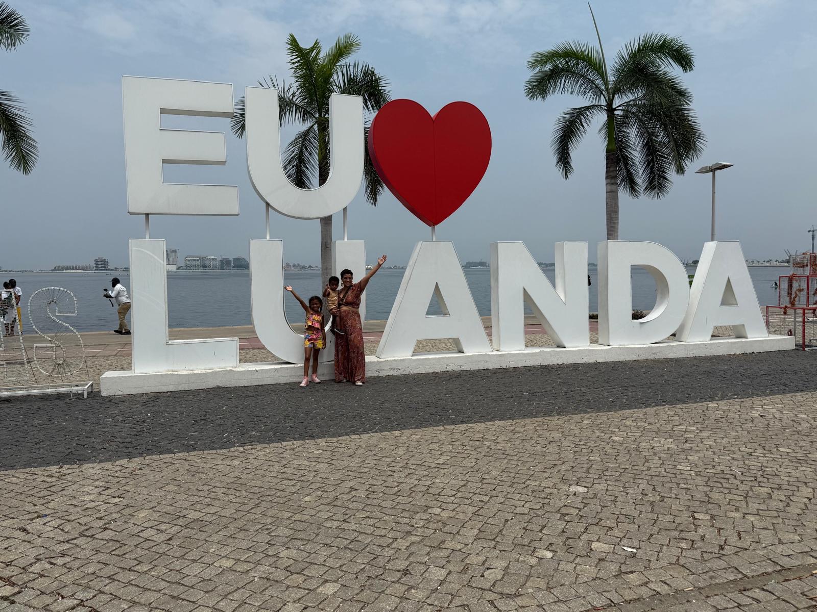 Julie Augusto and her daughter at the EU AMO LUANDA waterfront sign in Luanda, Angola