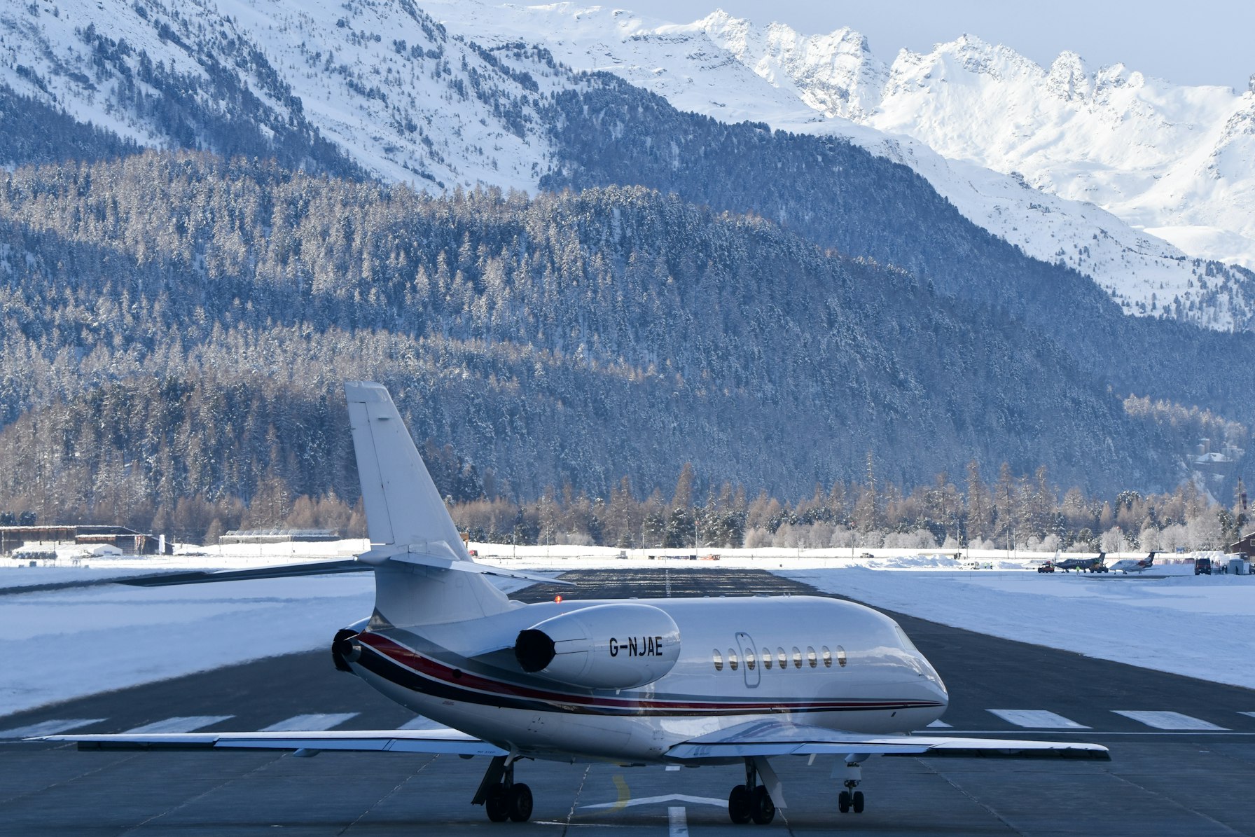 Private jet on a snowy runway with mountains behind, representing ultra-luxury private jet travel
