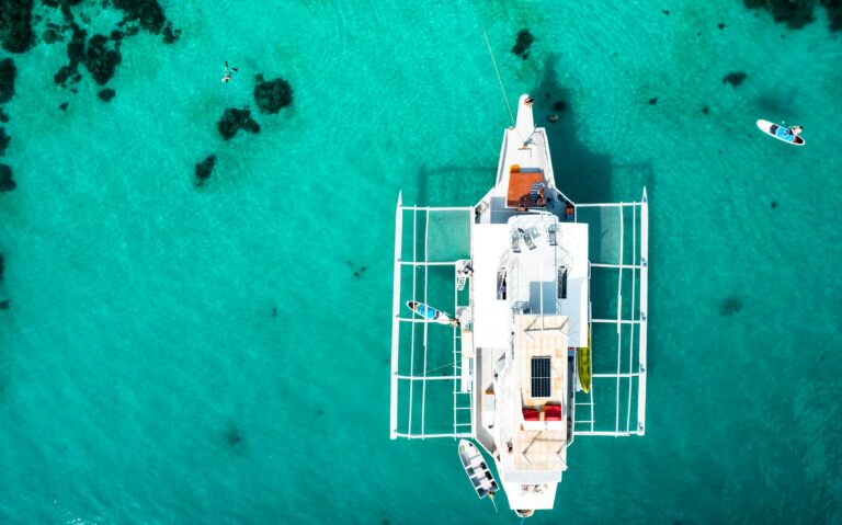 White catamaran floating on clear turquoise Red Sea water
