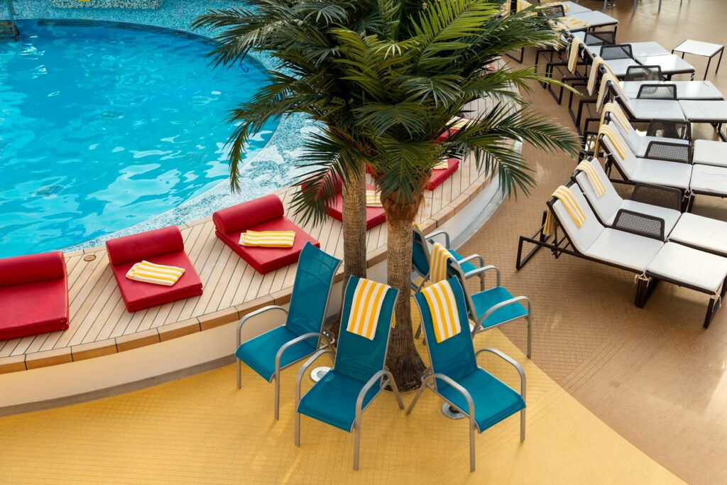 Empty sun loungers beside a ship swimming pool, the quiet that adult only cruises promise at sea