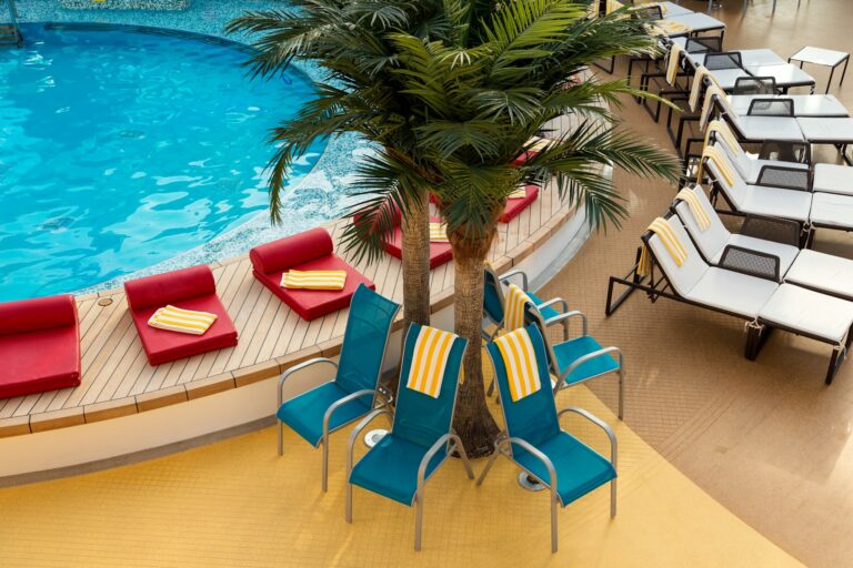 Empty sun loungers beside a ship swimming pool, the quiet that adult only cruises promise at sea