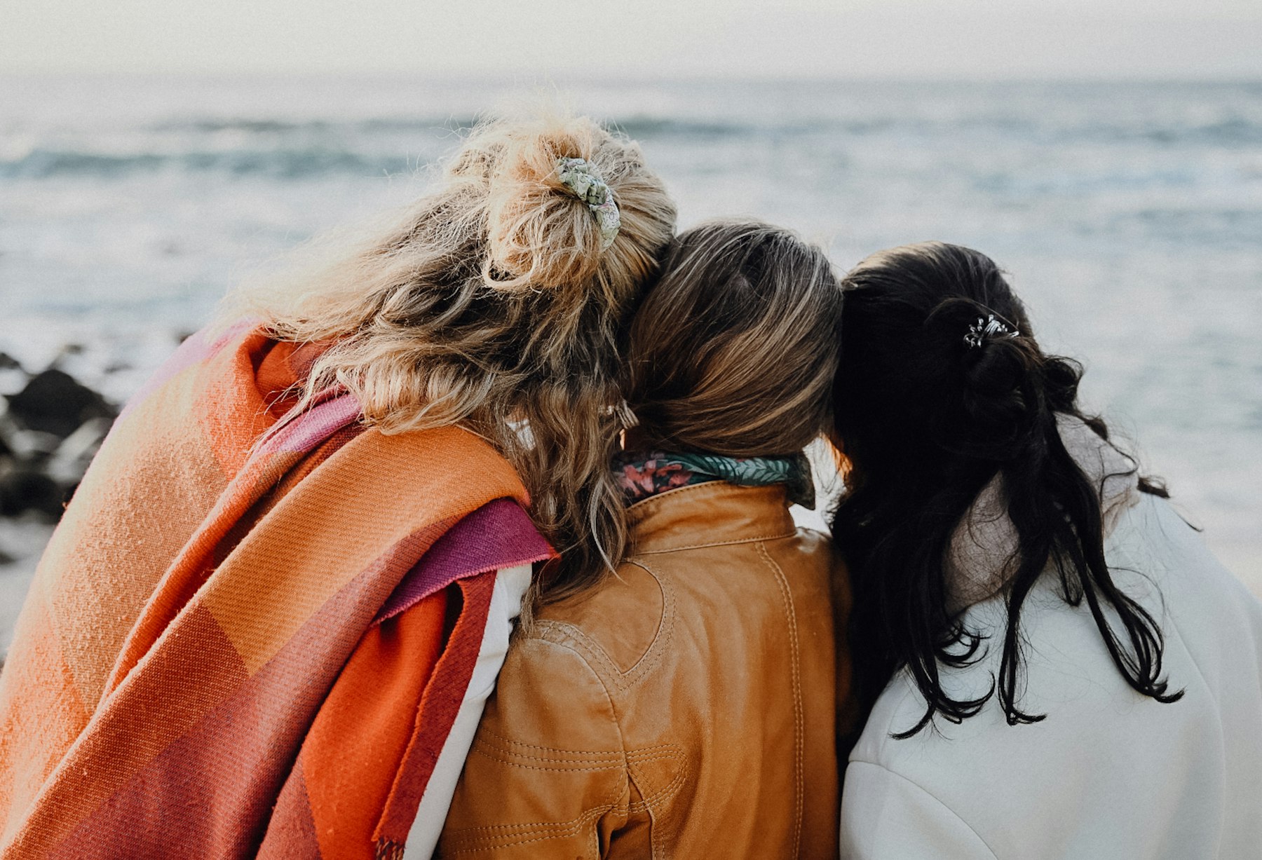 The best girls trip destinations start with the group: friends travelling together on a sunlit coastal terrace.