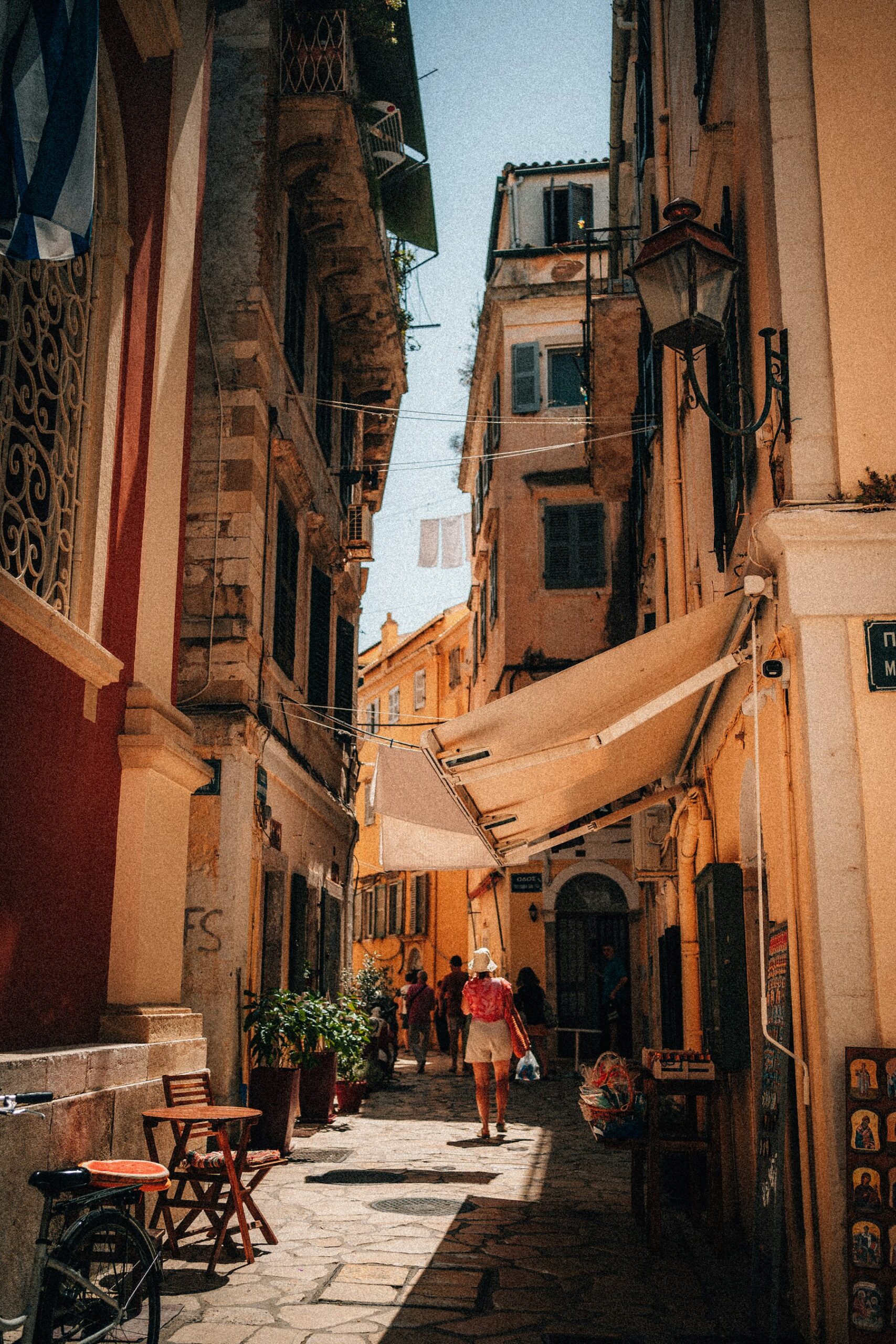 People walking a narrow street in the Old Town of Corfu, among the best Greek islands to visit for Venetian architecture