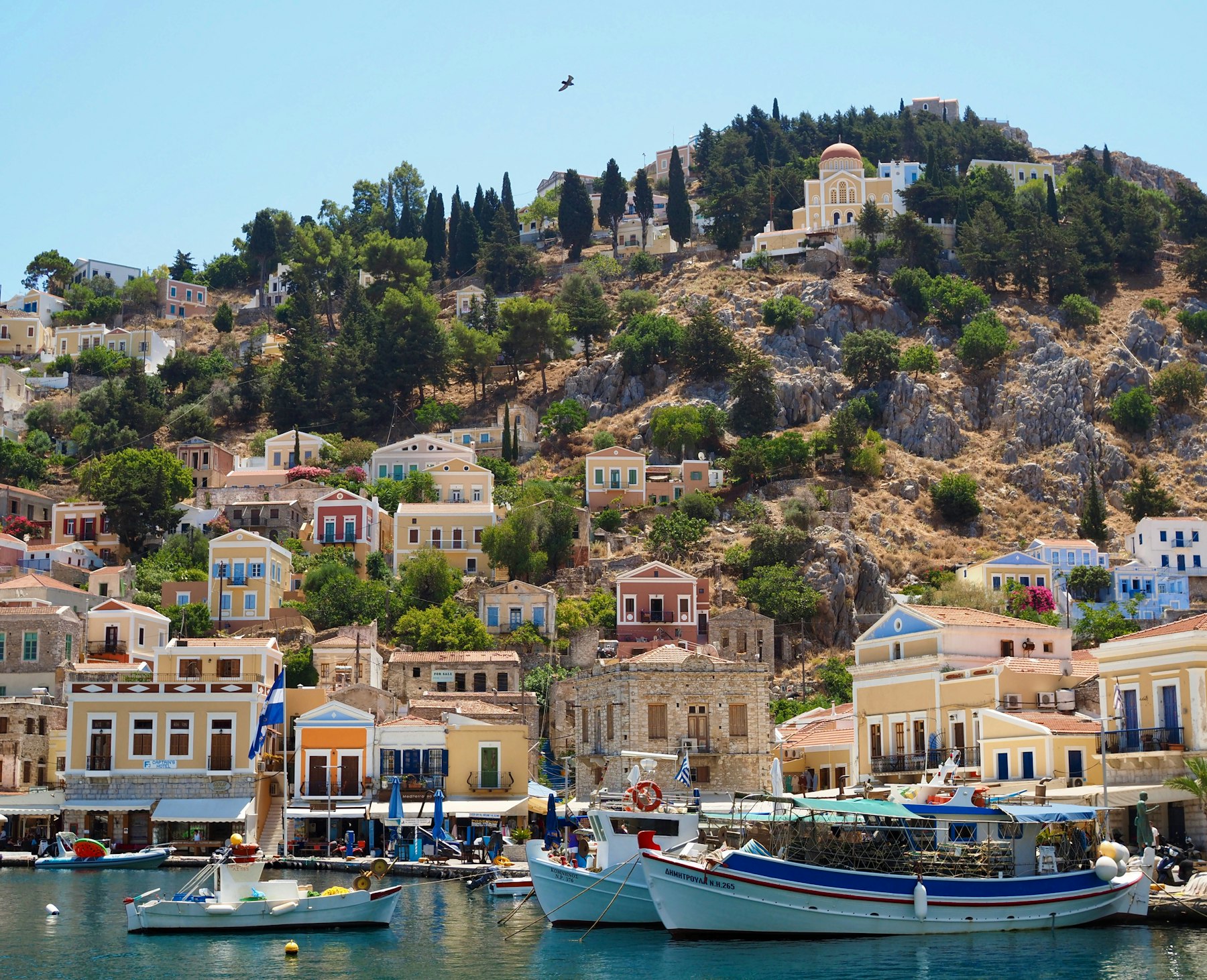 Neoclassical houses stacked above a harbour on Symi in the Dodecanese, the island group that holds two of the best Greek islands to visit