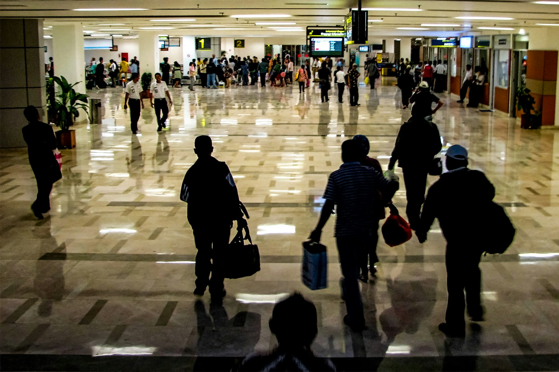 Passengers walking through a busy airport terminal, illustrating why the cheapest days to fly matter more than the day you buy