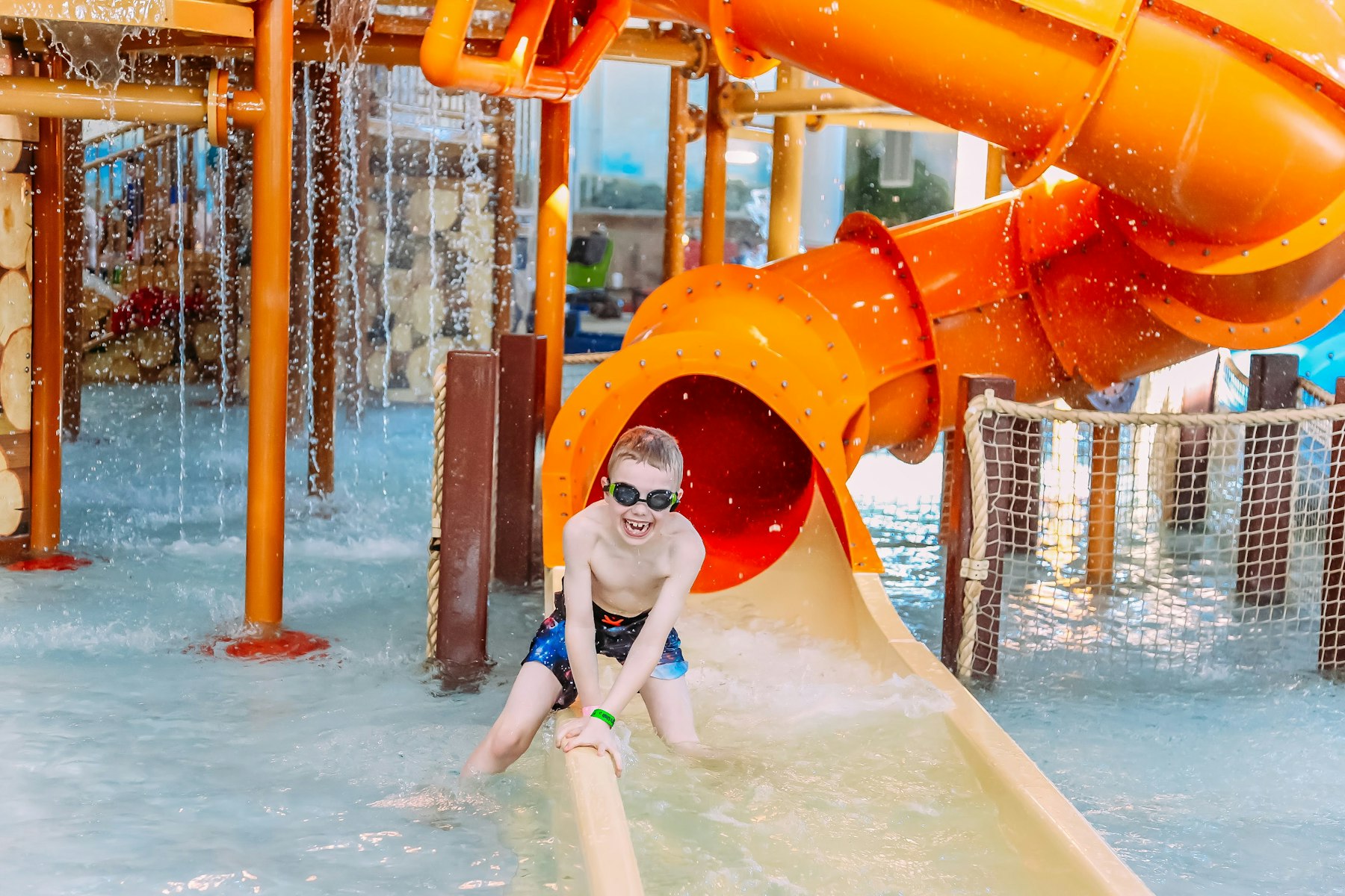A young boy riding a waterslide, the kind of waterpark feature family friendly cruise lines now build into ships and private islands.