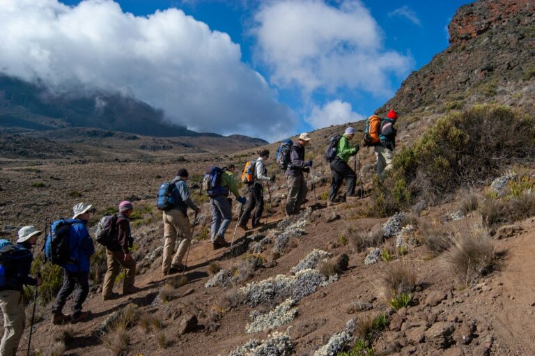 Climbers walking a high ridge on Mount Kilimanjaro in Tanzania, the peak at the centre of most Kilimanjaro climb tours