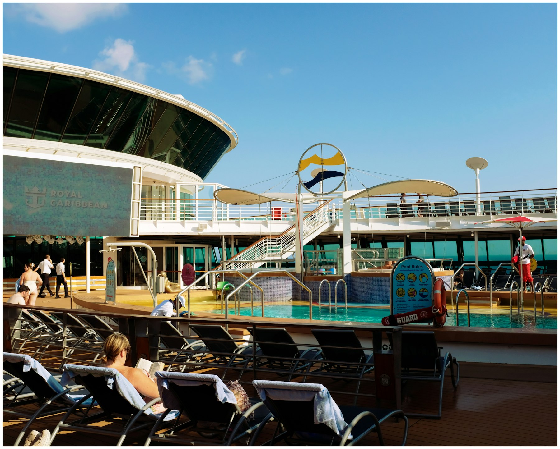 Loungers beside an uncrowded pool deck, the space ratio that separates luxury cruise lines from premium ones.