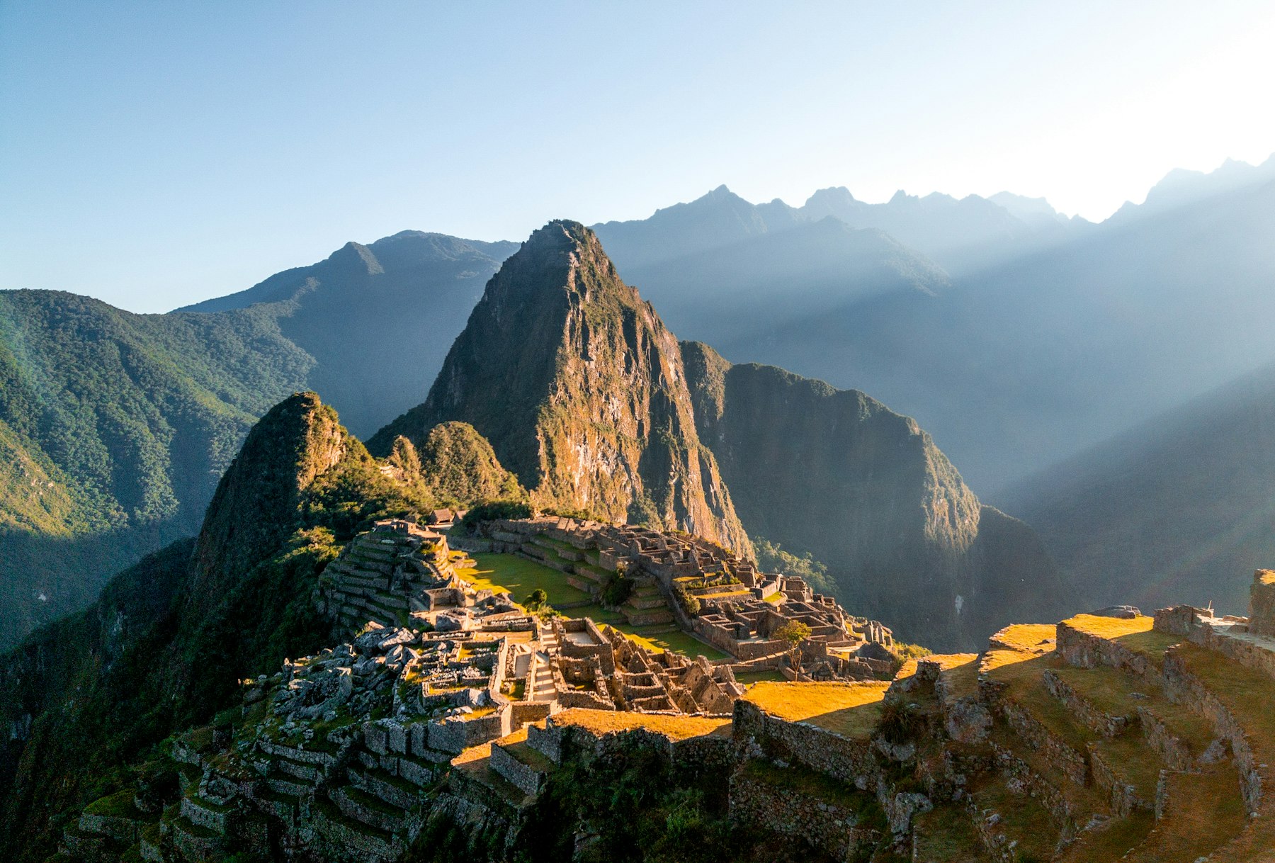 Sunlight falling across the stone ruins of Machu Picchu in the Peruvian Andes, the high point of a twelve-day Peru itinerary