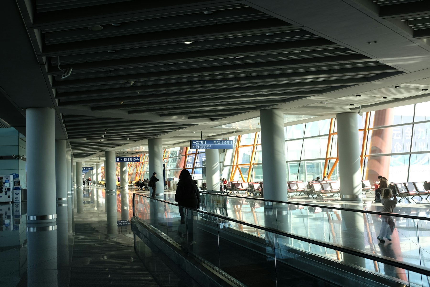 A traveller on a moving walkway in a modern airport terminal, heading for a flight booked with a Southwest Companion Pass.