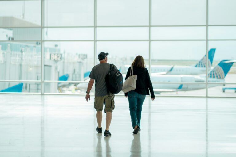 Two travellers walking together through Denver International Airport, the kind of trip a Southwest Companion Pass is built to halve.