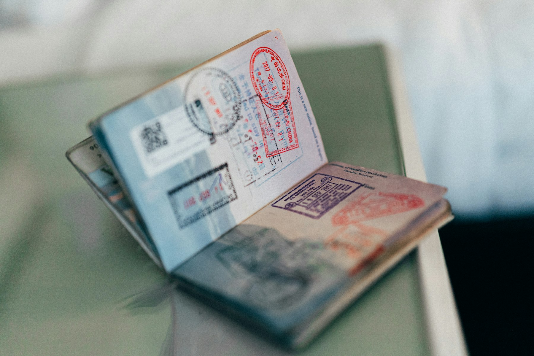 An open passport filled with colourful entry stamps, the record of what a travel rewards credit card is ultimately for
