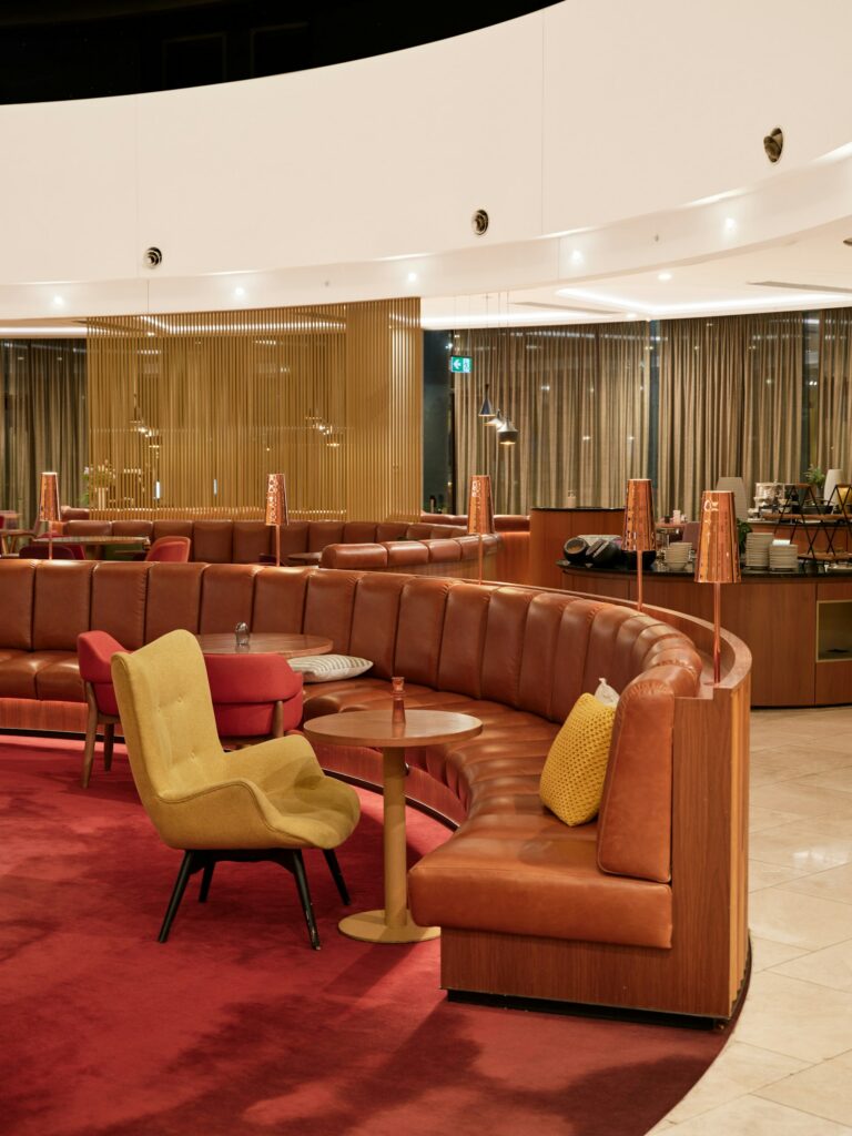 Curved leather booth seating and armchairs in an empty airport lounge at Canberra Airport.