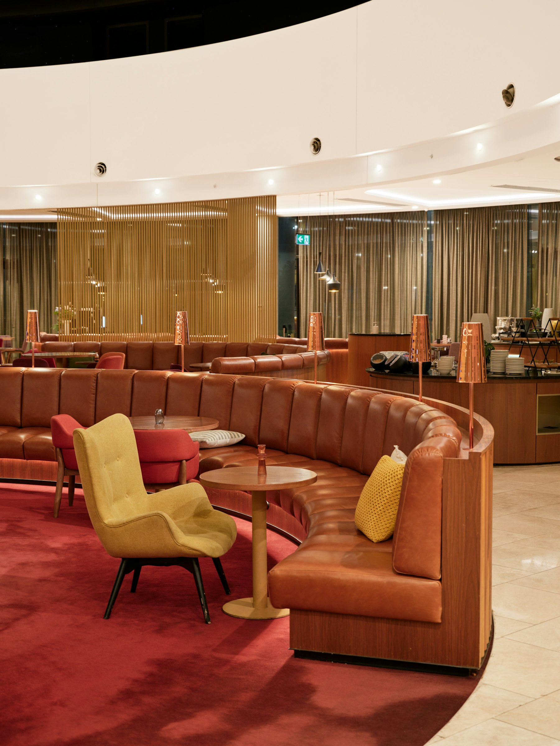 Curved leather booth seating and armchairs in an empty airport lounge at Canberra Airport.