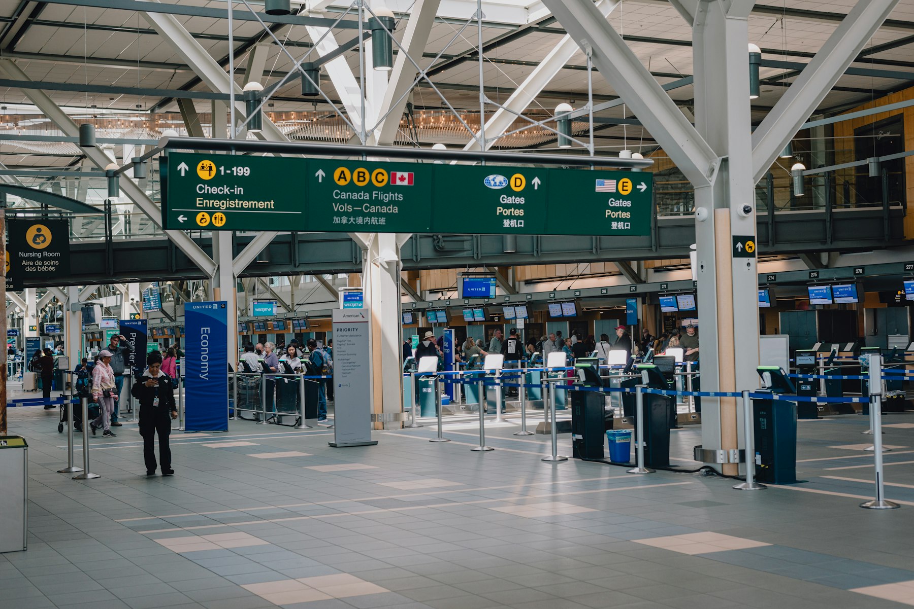Travellers crossing the bright departures hall at Vancouver International Airport, the concourse an airport lounge is sold as an escape from.