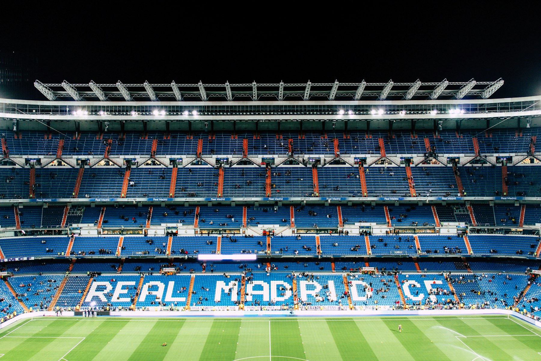 Empty blue seats spelling out Real Madrid C.F. inside the Santiago Bernabeu, the other Madrid ground visitors weigh against the Estadio Metropolitano.