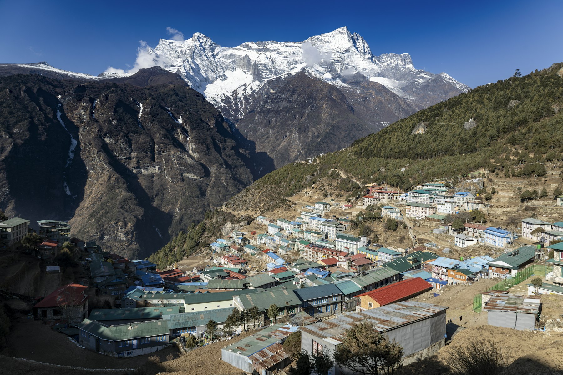 The village of Namche Bazaar on the Everest base camp trek, its painted roofs filling the valley below snow-capped Himalayan peaks