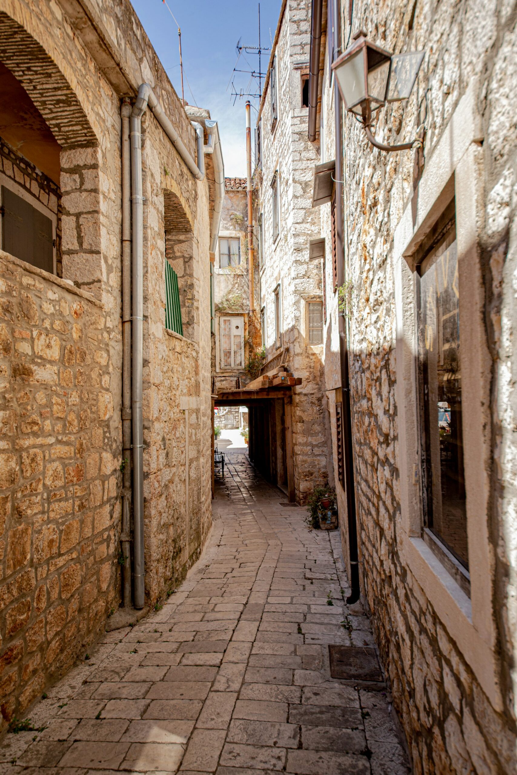 A narrow stone lane between old houses in Vrboska on Hvar, at the edge of the Stari Grad Plain