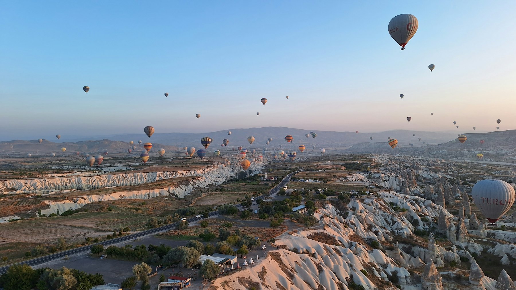 Hot air balloons over the eroded valleys of Cappadocia at dawn, the most photographed of all things to do in Turkey